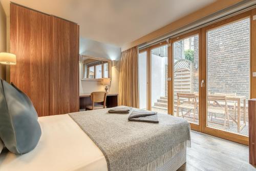 伦敦Grosvenor Mayfair的酒店客房设有一张床和一个大窗户