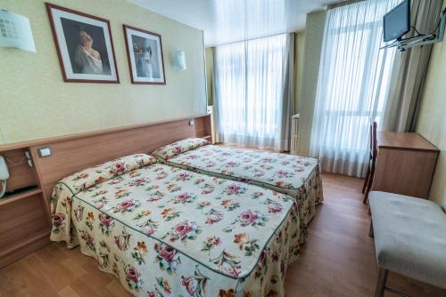 桑坦德Hotel Bedoya的一间卧室配有一张带花卉床罩的床