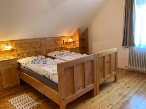 Klamm艾尔塔梅尔豪弗农家乐的一间卧室配有一张带木制橱柜的大型木床。