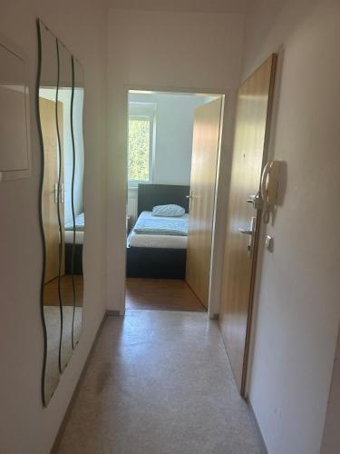 林茨Montel PARK - Traun的走廊上设有一张床和镜子的房间
