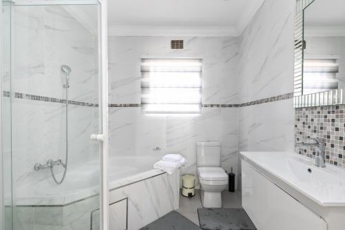 肯普顿帕克Signature Lodge的白色的浴室设有浴缸、卫生间和水槽。