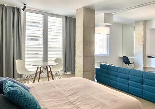 蓬费拉达Estudio的一间卧室配有蓝色的床和桌椅