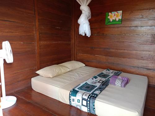 Gili GedeYellow Coco Gili Gede的卧室配有木墙内的一张床