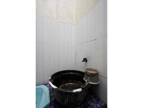 泗水OYO Life 93061 Kost Vicky Syariah的一间位于客房角落的带水桶的浴室