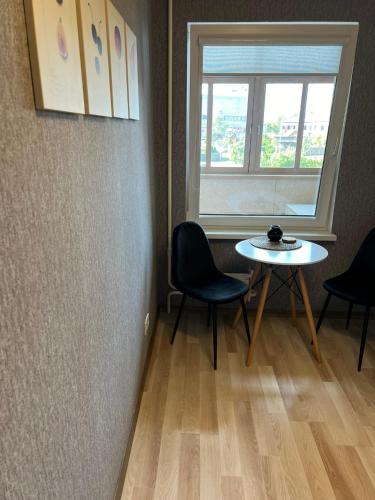 叶卡布皮尔斯Zemgales ielas apartamenti的客房设有桌椅和窗户。