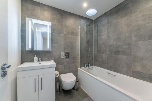 伦敦Luxury 2 Bed 2 Bath London Home - Vauxhall, Battersea & Nine Elms的浴室配有盥洗盆、卫生间和浴缸。