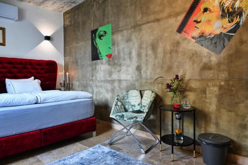 维多利亚Cittadella Suite的一间卧室配有红色的床和椅子