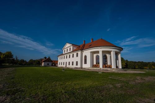 布热茨拉夫Zámeček - Chateau Lány - Depandance Stroodel的一座白色的大建筑,在田野上有一个红色的屋顶