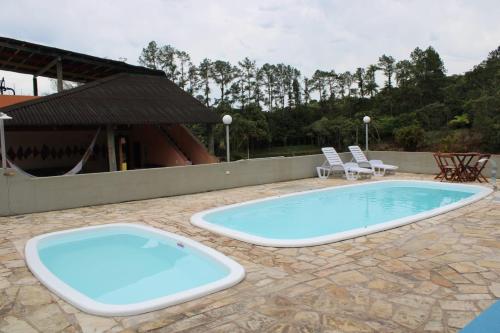 卡纳内亚拉加马尔生态酒店的一座带椅子的庭院和一座建筑中的游泳池