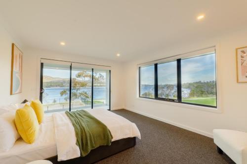 霍巴特Hobart 4-bedroom Spacious Waterfront House的一间卧室设有一张大床和大窗户