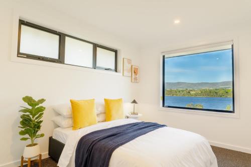 霍巴特Hobart 4-bedroom Spacious Waterfront House的一间白色卧室,配有床和2个窗户