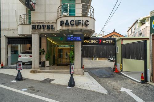 平泽市Pacific7 Hotel的酒店大楼前面有街道标志