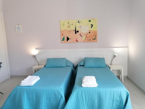 坎波巴索Residenza Guglielmi的配有蓝色床单的客房内的两张床