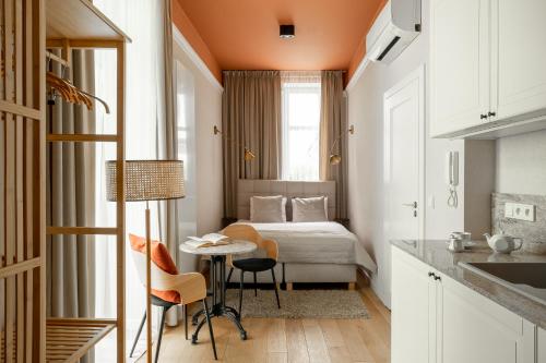 克拉科夫Avanti Palazzo的小房间设有一张床、一张桌子和椅子