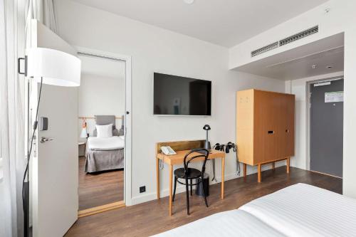 斯德哥尔摩斯尔蒙布罗马贝斯特韦斯特酒店的一间卧室配有一张床、一张书桌和一台电视。