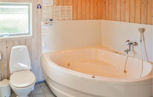 博恩瑟Stunning Home In Bogense With 4 Bedrooms, Sauna And Wifi的带浴缸和卫生间的浴室。