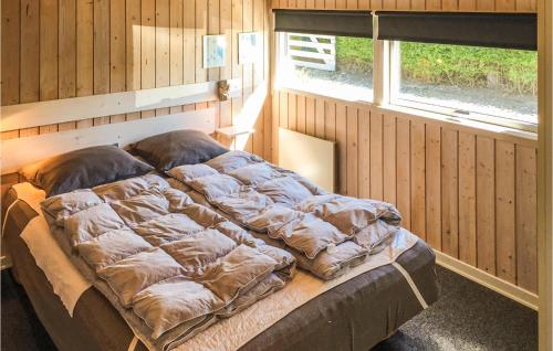 博恩瑟Stunning Home In Bogense With 4 Bedrooms, Sauna And Wifi的木制客房内的一张大床,设有窗户