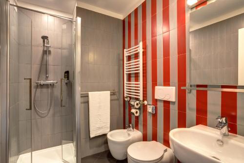 罗马罗马中央火车站麦宁格酒店的浴室配有卫生间、盥洗盆和淋浴。
