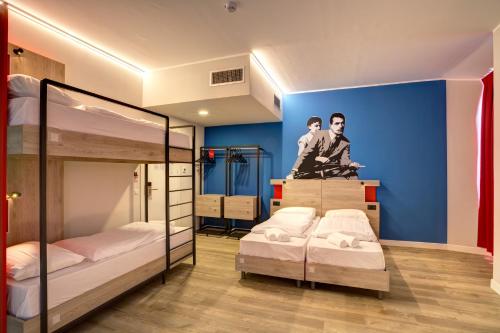 罗马罗马中央火车站麦宁格酒店的一间卧室设有两张双层床和蓝色的墙壁