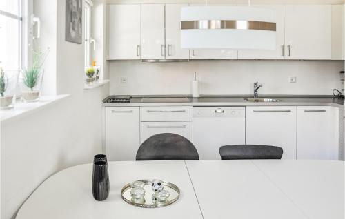 博恩瑟Lovely Apartment In Bogense With Sauna的白色的厨房配有白色橱柜和水槽
