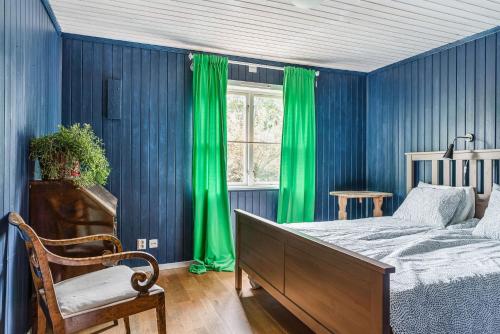 孔斯戈登Charming holiday home in Kungsgarden, Gastrikland的一间卧室设有蓝色的墙壁、绿色的窗帘和床