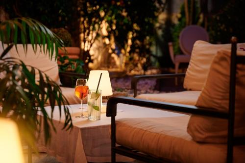 罗维尼海瑞缇吉安吉洛多拉酒店的一张桌子,旁边是一张沙发,旁边是一杯葡萄酒