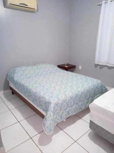 Jerônimo MonteiroRosa do deserto的一间卧室配有一张带蓝色棉被的床