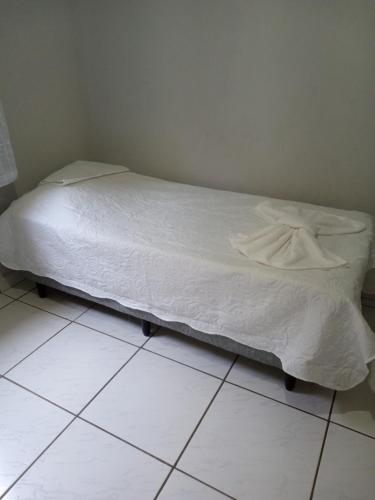 Jerônimo MonteiroRosa do deserto的卧室内一张位于瓷砖地板上的床