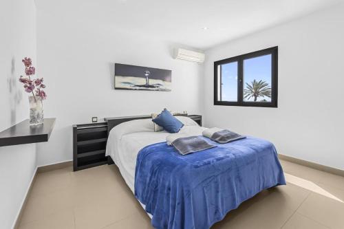 蒂亚斯Casa Airalba的一间卧室配有一张带蓝色床单的床和一扇窗户。