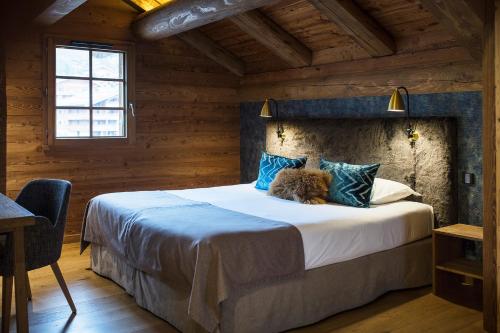 拉克吕萨莱斯希麦斯公寓式酒店的木制客房内的一间卧室配有一张大床
