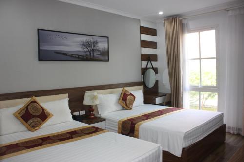 下龙湾Huong Duong Sunflower的酒店客房设有两张床和窗户。