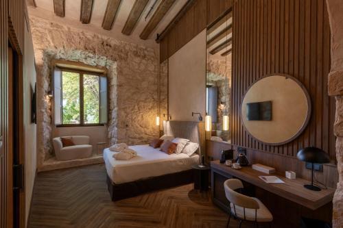 布里韦加Castilla Termal Brihuega的一间卧室配有一张床和镜子