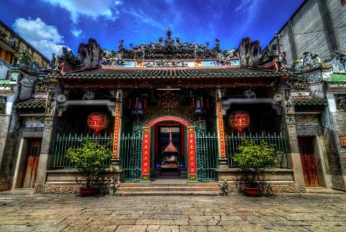 胡志明市T Zone Hostel的前方有门和鲜花的亚洲建筑
