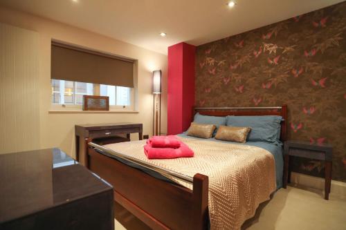 伦敦The London Nest: 2BR City Haven的一间卧室配有一张红色枕头的床