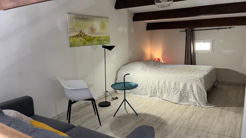 勒·雷约尔·卡纳德尔·苏尔Appartement - Résidence Le Paradou的一间卧室配有一张床、一把椅子和一张沙发