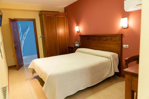 TorreperogilPensión Restaurante Casablanca的卧室配有白色的床和木制床头板