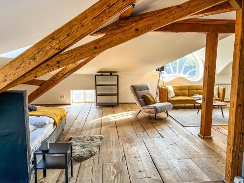 基姆湖畔普林Loft-Wohnung im Herzen von Prien - 100m2 - SmartTV的阁楼卧室配有1张床和1把椅子