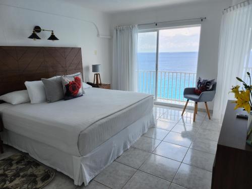 科苏梅尔Coral Princess Hotel & Dive Resort的一间卧室配有一张床,享有海景