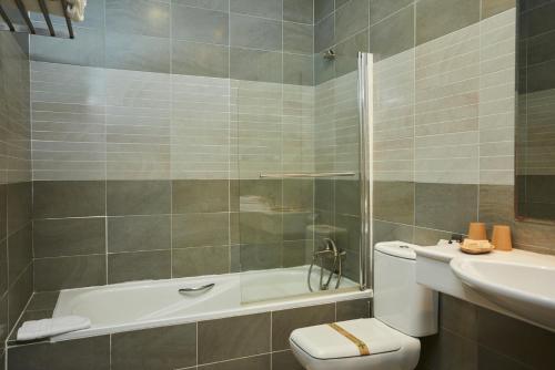 坎德莱达Hotel El Mirlo Blanco的带浴缸、卫生间和盥洗盆的浴室