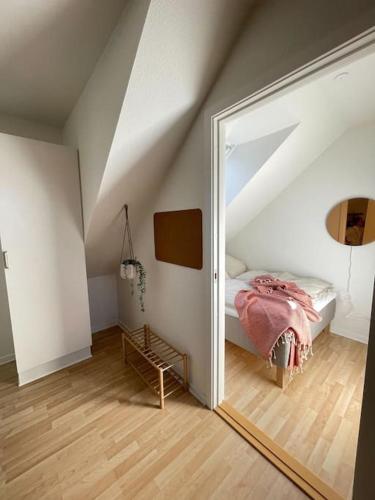 欧登塞Ophold i hjertet af Odense!的一间带镜子的卧室和阁楼内的一张床