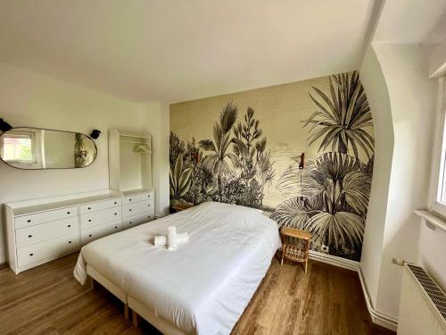 泰昂维Charmant Apt White&Grey 3BR Proche Centre et Gare的卧室配有一张床,墙上挂有绘画作品