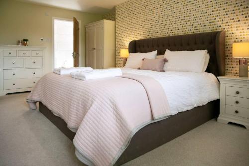 伊登Remarkable 4-Bed House Near Leeds Airport的一间卧室配有一张大床和两条毛巾