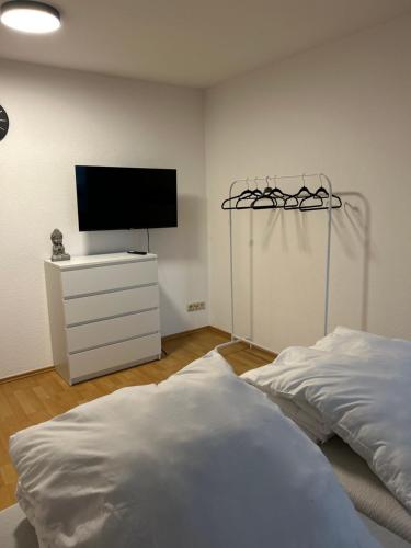 法伦达尔Vallendarer Stübchen的一间卧室配有一张床和一台平面电视