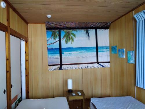 那霸Miyagi Apartment Tomari的一间卧室设有窗户,享有海滩美景
