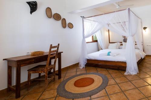 迭戈苏瓦雷斯Royal Sakalava的一间卧室配有一张床、一张桌子和一张桌子
