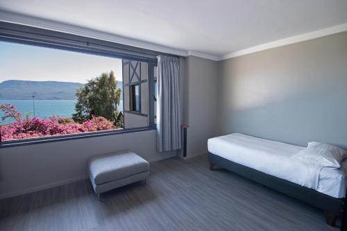 普孔Hotel Enjoy Pucon的一间卧室设有一张床和一个大窗户