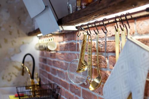 下乌斯奇基PORANEK W GÓRACH的厨房配有铜质餐具,挂在砖墙上