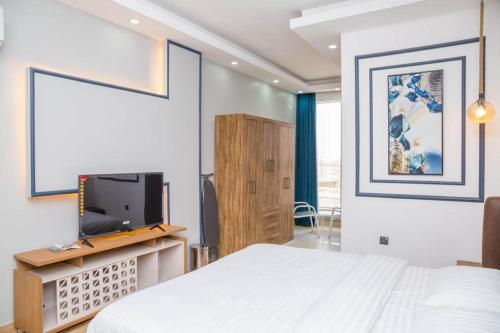 塞拉莱Itten Plaza Hotel 2的一间卧室配有一张床和一台平面电视