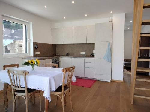普拉托·阿罗·斯泰尔维奥Haus am Brunnen的厨房配有白色的桌椅和桌子,厨房