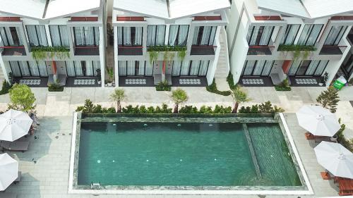 贡布Emerald Residence Kampot的享有带遮阳伞的大楼游泳池的顶部景致